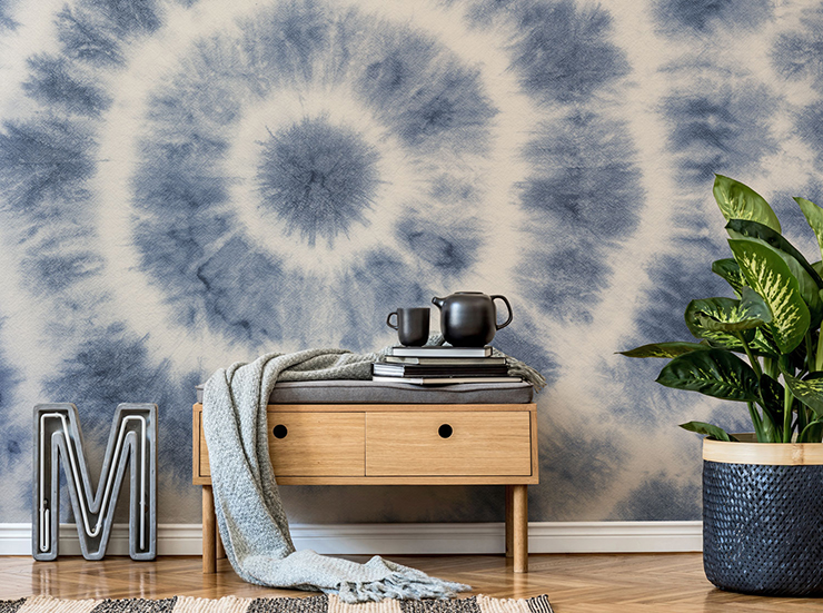 tie dye blue and white wallpaper in lounge with natural wooden drawers and a tropical potted plant