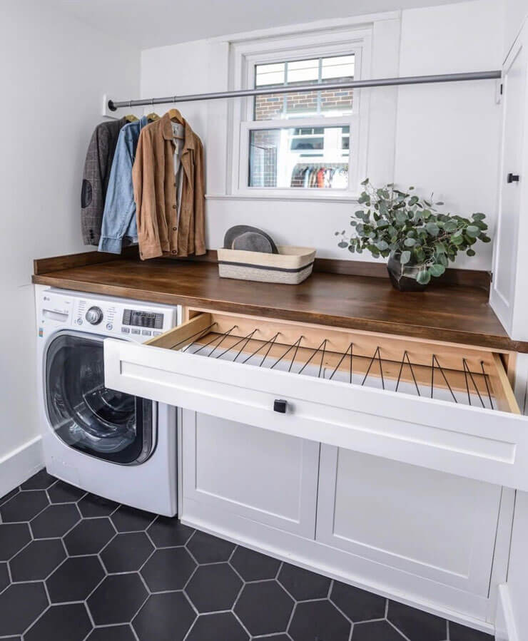 white and wooden drying drawer in small laundry room under window