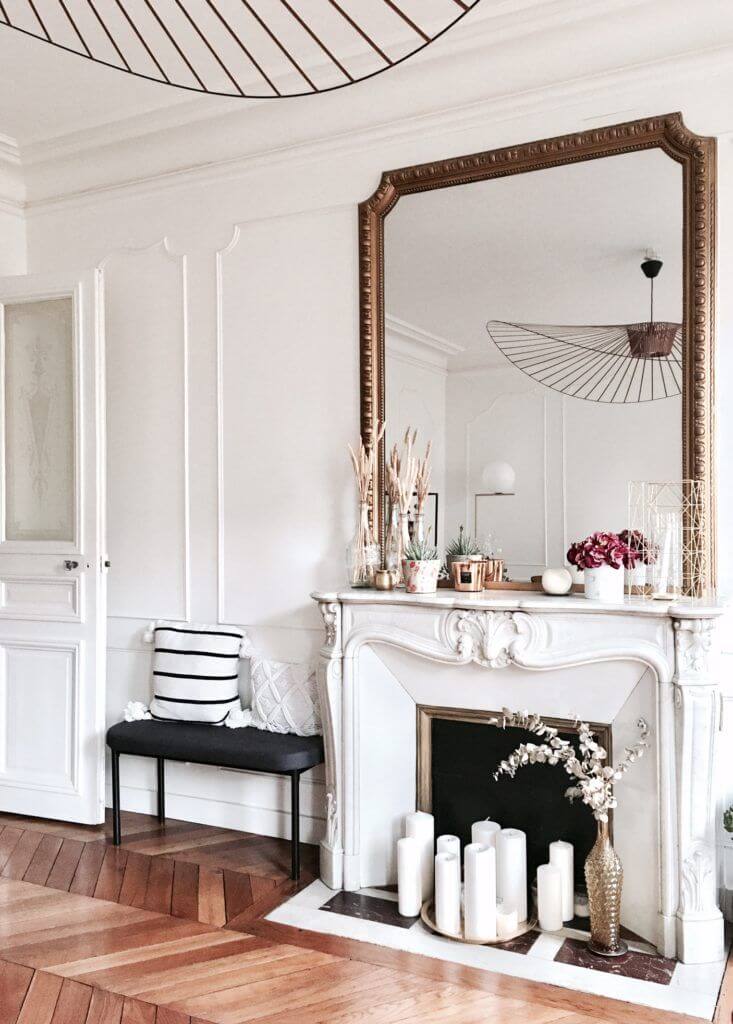 vintage styled lounge with large gold mirror above fire place