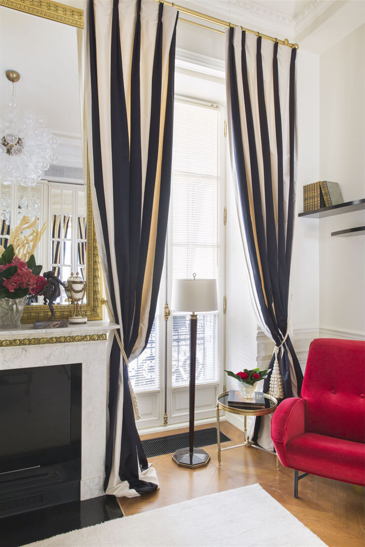 black and white striped curtains in white room with lipstick red chair