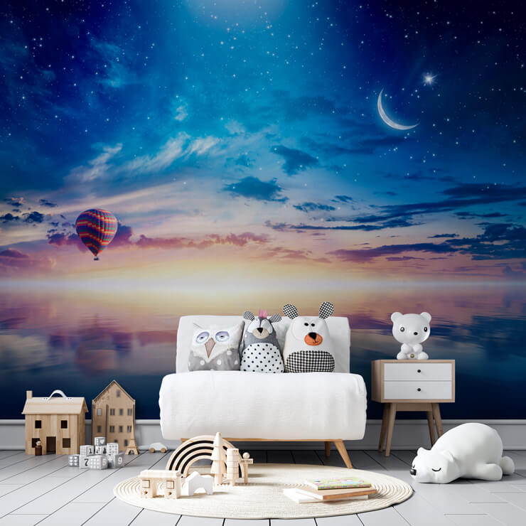 night sky hot air balloon mural in nursery with white chair and toys