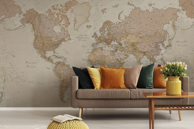 Beige living room with a brown couch with orange and mustard cushions with a natural map wallpaper