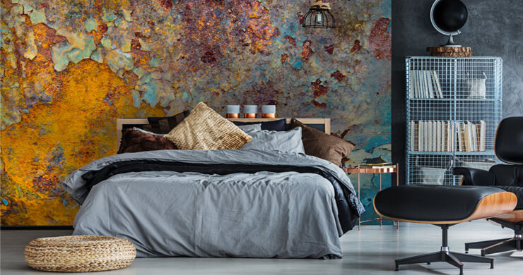 Metal fall inspired wallpaper in a dark bedroom with grey bedsheets and metal furniture 
