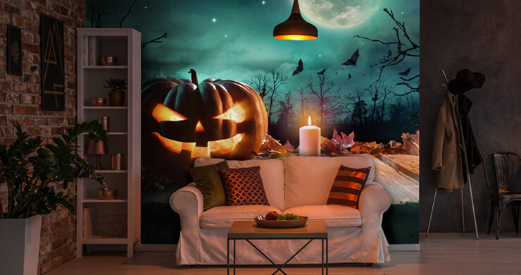 Pumpkin carving ideas in a dark living room with a large pumpkin wall mural on the wall