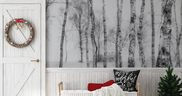 Scandinavian Christmas Decorations in a hallway with a black and white tree mural and a green Christmas wreath