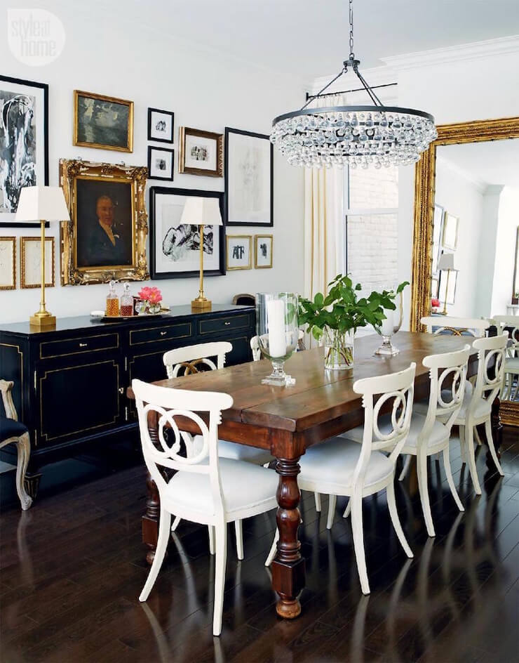 Dining room inspiration with modern victorian style with a dark floor, large wooden table, and ornate picture frames