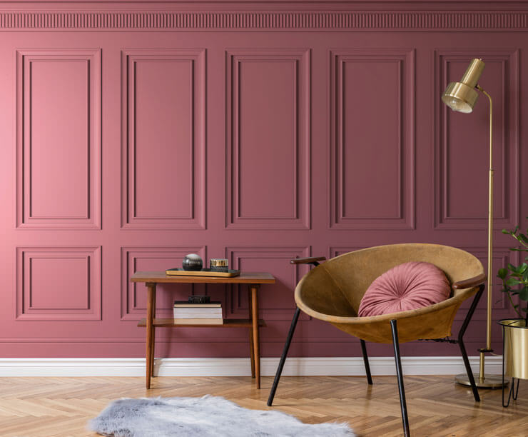 Viva Magenta inspired pink panel wallpaper in a living room with a gold chair and lamp and wooden floor