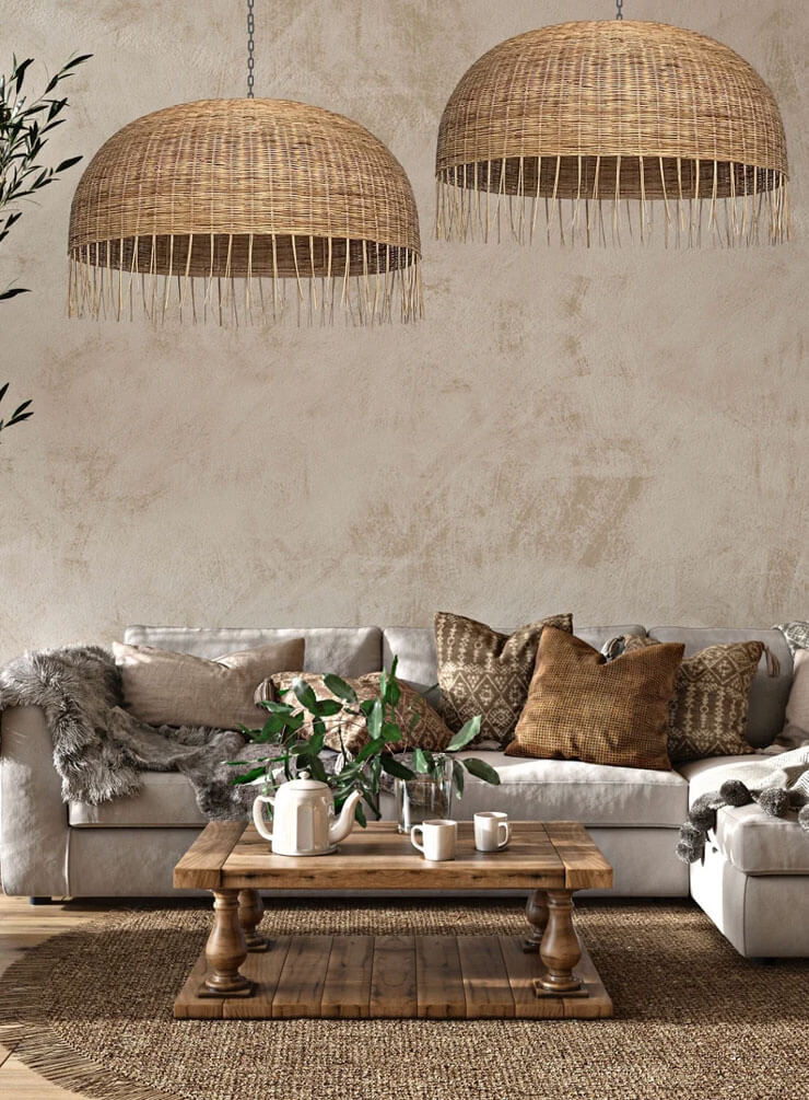 Beige living room with a light grey sofa, dark rattan rug, and large rattan pendant light shades