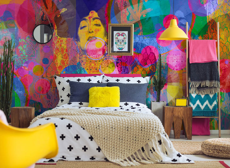 Eclectic interiors of a bedroom with a bright and colorful wall mural and bright yellow accessories