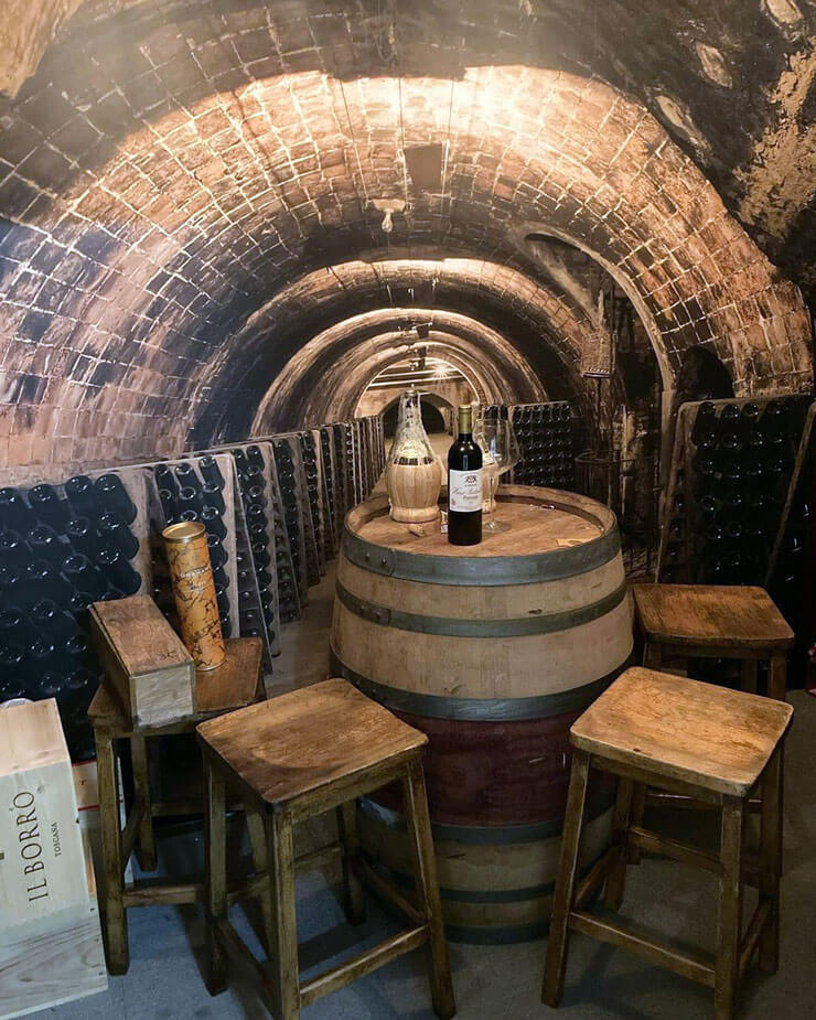 Bar interior with a 3D wallpaper of a wine cellar in a bar with rustic furniture