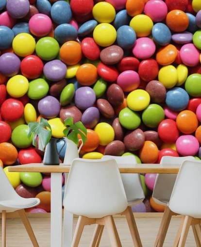 Carta da parati murale con cioccolatini color arcobaleno chiamata Colourful Sweets per camerette per bambini, negozi di dolciumi e aziende