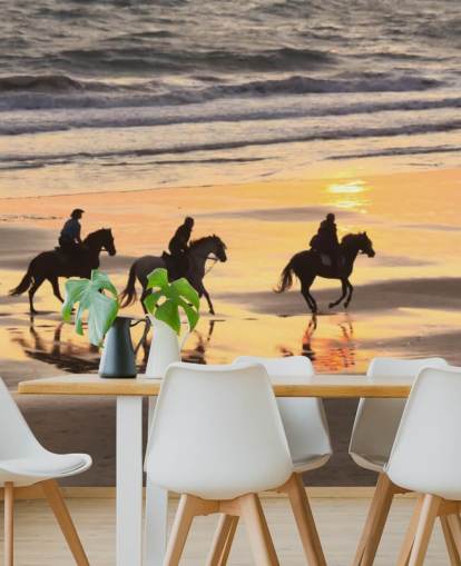 Cavalli che corrono su una spiaggia al tramonto Wallpaper