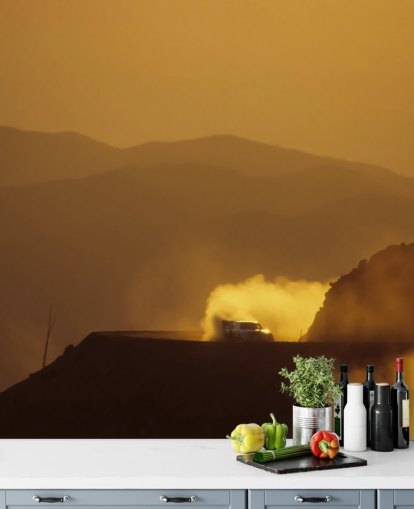 Auto auf der staubigen Bergstraße bei Sonnenuntergang Wallpaper