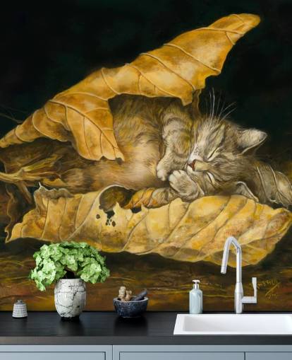 kitten asleep in autumn leaves