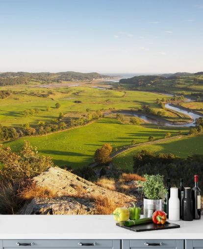 Zonsondergang in groen landschap muurschildering