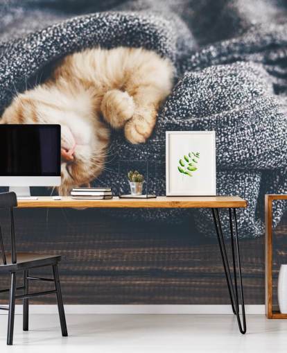 ginger kitten slaapt op grijze deken