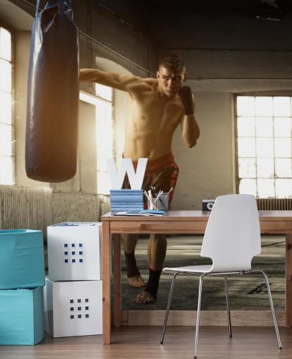 Ung man boxar i lager tapet