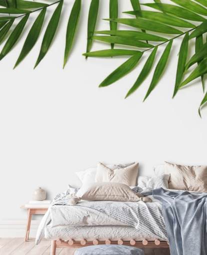 palmbladeren hangen over wit behang