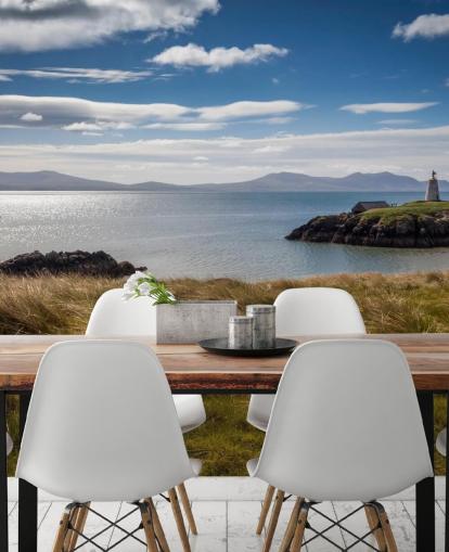 Barca sul mare calmo lungo una costa rurale a Llanddwyn