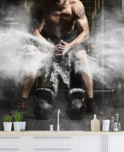 Entrenamiento de hombre musculoso con pesas rusas en el papel tapiz del gimnasio