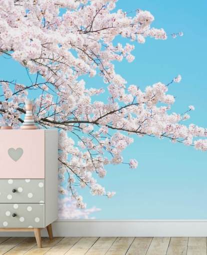 Decorazione murale con fiori rosa contro un cielo blu brillante