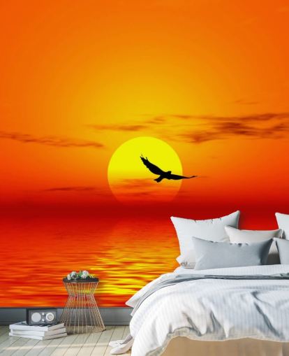 Vogel fliegt bei Sonnenuntergang über den Ozean Fototapete