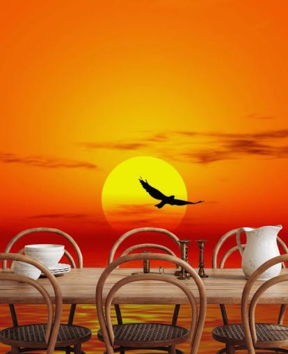 Vogel fliegt bei Sonnenuntergang über den Ozean Fototapete