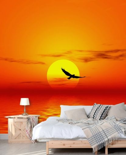 Vogel fliegt bei Sonnenuntergang über den Ozean Fototapete