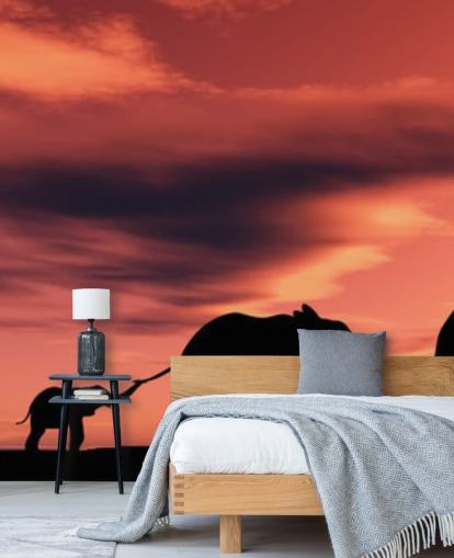 Elefanttiperhe auringonlaskun seinämaalauksessa