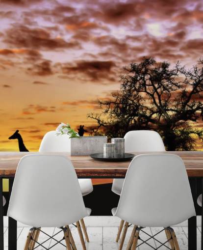 kirahvien ja norsujen siluetit auringonlaskun taivaan taustakuvaa vasten