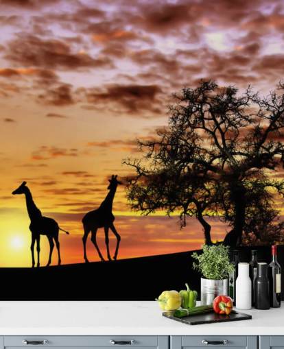 Giraffen- und Elefanten-Silhouetten vor Sonnenuntergangshimmel-Tapete