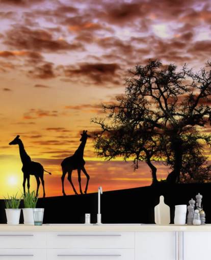 Giraffen- und Elefanten-Silhouetten vor Sonnenuntergangshimmel-Tapete