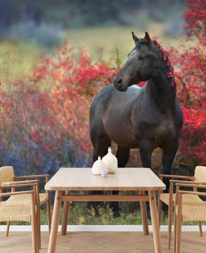 Schwarzes Pferd umgeben von roten Beerensträuchern und Beeren in der Mähne Fototapete
