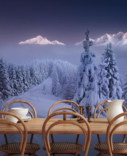 snowy forest and piste with mountains in the distance wallpaper