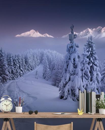 snowy forest and piste with mountains in the distance wallpaper