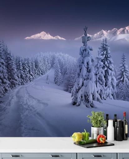 snowy forest and piste with mountains in the distance wallpaper