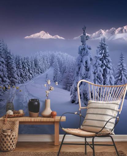 snowy forest and piste with mountains in the distance wallpaper