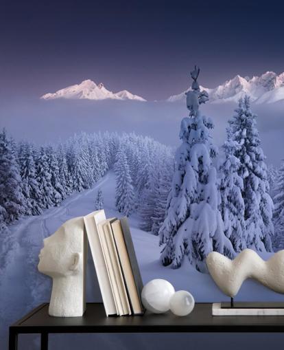 snowy forest and piste with mountains in the distance wallpaper