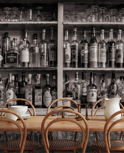 black and white bottles on shelf behind a bar wallpaper