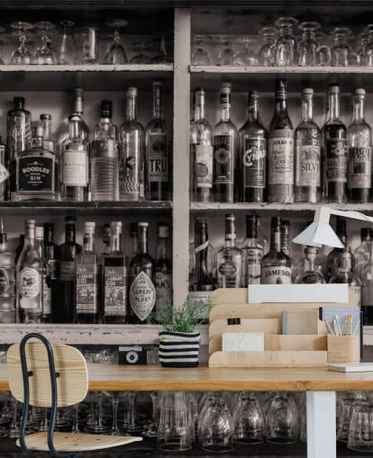black and white bottles on shelf behind a bar wallpaper
