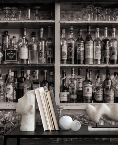 black and white bottles on shelf behind a bar wallpaper