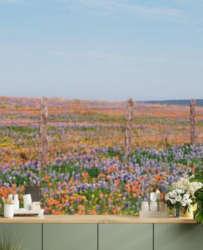 campo de prado com flores laranja, roxas e amarelas papel de parede