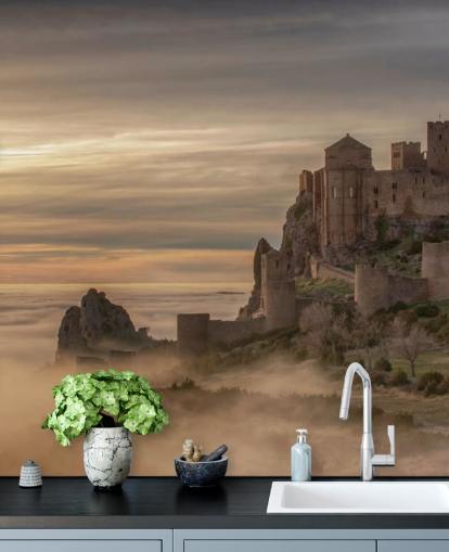 spanish castle on mountaintop above mist mountains wallpaper