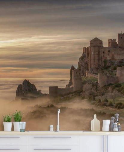 spanish castle on mountaintop above mist mountains wallpaper
