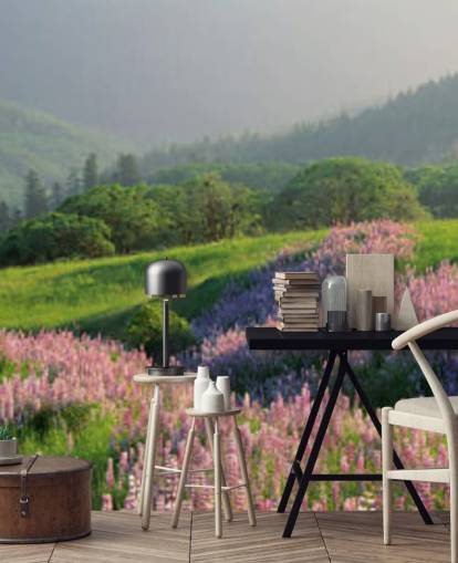 hellviolette und rosa Wildblumen im Feld mit grünen Hügeln Tapete