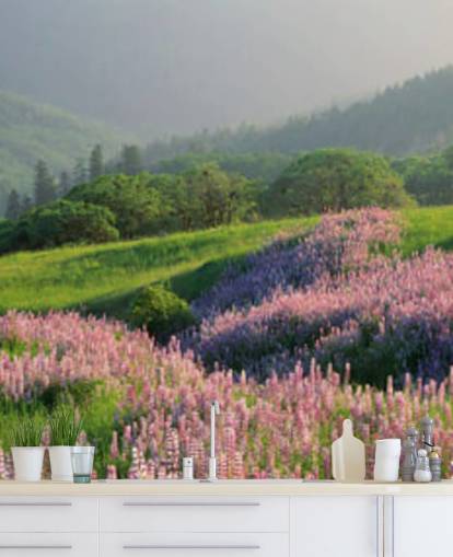 light purple and pink wild flowers in field with green hills wallpaper