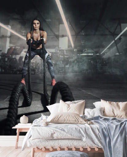 Powerful muscular woman fitness trainer do battle workout with ropes mural