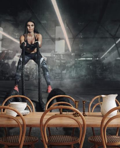 Potente entrenador físico mujer musculosa hacer entrenamiento de batalla con mural de cuerdas