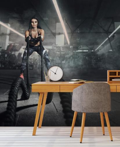 Potente entrenador físico mujer musculosa hacer entrenamiento de batalla con mural de cuerdas