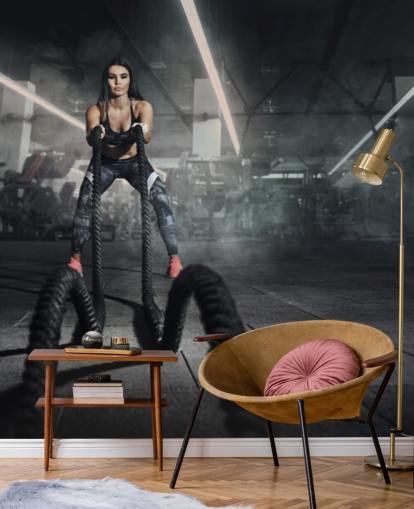 Powerful muscular woman fitness trainer do battle workout with ropes mural